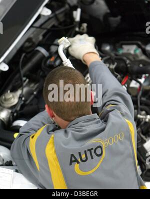 (Dpa) - Il logo 'Auto 5000' è visto sul retro di un lavoratore che assembla parti della nuova VW Touran a Wolfsburg, in Germania, 13 gennaio 2003. Il Touran è un van basati sul modello della VW Golf. I lavoratori sono stati impiegati nell'ambito del progetto "5000 mal 5000' (5.000 volte 5.000), che mira t Foto Stock