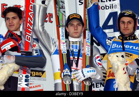 (Dpa) - finlandese ponticello sci Janne Ahonen (C) cheers dopo il terzo salto a La cinquantunesima quattro Hill nel torneo di Innsbruck, Austria, 4 novembre 2003. Ahonen vince e incrementa il suo vantaggio in classifica generale. Austrian Florian Liegl arriva al secondo posto davanti al suo connazionale Martin Hoellwarth (R). Foto Stock