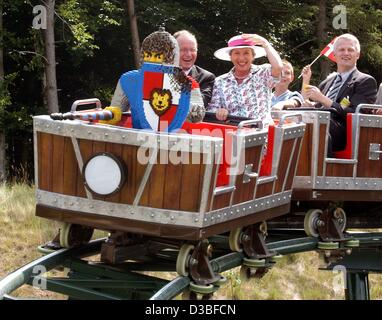 (Dpa) - Danish principessa Benedikte (C) detiene sul suo cappello durante il proprietario del gruppo Lego, Kjeld Kirk Kristiansen (L), si siede accanto a lei e sorrisi durante la corsa di apertura di un lego roller coaster presso il parco Legoland vicino Guenzenburg, Germania, 26 giugno 2003. La principessa ha inaugurato il nuovo rullo Foto Stock