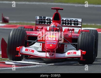 (Dpa) - Tedesco pilota di Formula Uno Michael Schumacher (Ferrari) poteri attraverso la nuova curva durante il corso di formazione gratuito al Nuerburgring race track, Germania, 27 giugno 2003. La curva è stata ricostruita da richiesta del tedesco di formula uno pilota e campione del mondo Michael Schumacher. La curva deve essere adesso Foto Stock