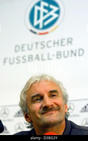 (Dpa) - Rudi Voeller, l'allenatore della nazionale tedesca di calcio, e sorrisi nella parte anteriore del logo del calcio tedesco association (DFB) durante una conferenza stampa tenutasi a Glasgow, Scozia, 6 giugno 2003. La Germania dovrà affrontare la Scozia nella partita di qualificazione per i campionati europei il 7 giugno. Foto Stock