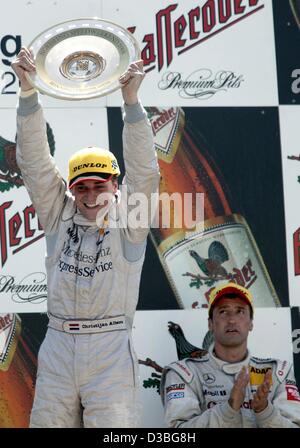 (Dpa) - Olandese pilota Mercedes Christijan Albers cheers mentre egli presenta il trofeo dopo aver vinto il tedesco touring car masters (Deutsches Tourenwagen Masters, DTM) sul Norisring racetrack in Nuremberg, Germania, 22 giugno 2003. Albers sostituisce il suo compagno di squadra Bernd Schneider (R) sul primo posto e vincere Foto Stock