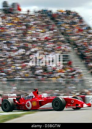 (Dpa) - tedesco di Formula Uno del campione del mondo in carica Michael Schumacher (Ferrari) razze passato la tribuna con gli spettatori sul Circuito Gilles Villeneuve formula one racing via durante il Gran Premio del Canada a Montreal, Canada, 15 giugno 2003. Michael Schumacher vince la gara e conduce in standin globale Foto Stock