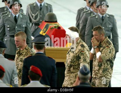 (Dpa) - Bundeswehr soldati sono profondamente commosso quando essi passano per la bandiera coperta bara di uno di loro uccise compagni di ISAF, l'aeroporto di Colonia, Germania, 10 giugno 2003. Il 7 giugno quattro tedesco ISAF (International Security Assistance Force) i soldati morti in un attacco a Kabul, Afghanistan. Un taxi aveva speronato Foto Stock