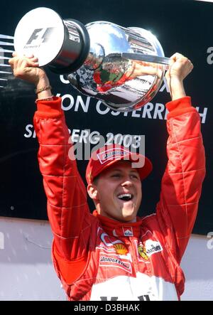 (Dpa) - tedesco di formula one champion Michael Schumacher della Ferrari jubilates con la sua coppa dopo aver vinto il Gran premio d'Austria sulla A1-Anello pista di Spielberg, Austria, 18 maggio 2003. È la sua terza vittoria di questa stagione. Foto Stock