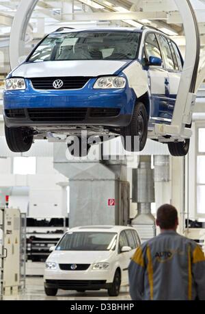 (Dpa) - Un dipendente Volkswagen sta facendo l'accettazione definitiva del nuovo modello VW Touran a Wolfsburg, Germania, 26 marzo 2003. Il Touran è un furgone compatto basato sul modello della VW Golf ed è stato offerto dal marzo per meno di 20.000 euro. Volkswagen intende vendere 130.000 Tourans nel 2003 e Foto Stock