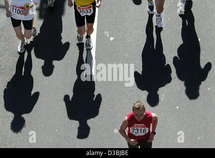 (Dpa) - I partecipanti alla prima maratona del Reno gettano le loro lunghe ombre sull'asfalto della strada a Duesseldorf in Germania, 4 maggio 2003. Circa 8.000 atleti parcticpate nella maratona. Foto Stock