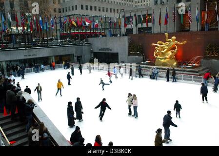 (Dpa) - Persone pattinare sulla pista di ghiaccio di fronte al Rockefeller Center di New York, 15 febbraio 2003. La statua dorata che mostra Prometeo sorge in background. Completato nel 1940, il Rockefeller Center doveva essere la nuova casa della Metropolitan Opera. L'Opera tirata fuori dal trattare un Foto Stock