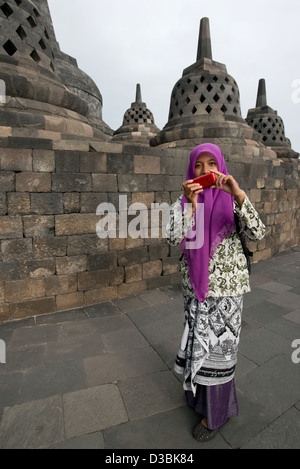 Una giovane donna indonesiana si prepara a prendere una foto di Borobudur tempio buddista in Java, Indonesia Foto Stock