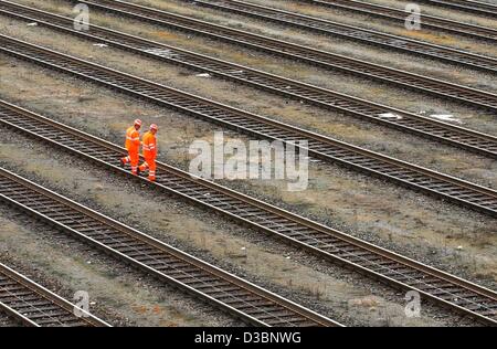 (Dpa) - due lavoratori delle ferrovie tedesche (Deutschen Bahn AG) attraversano le vie di un cantiere di smistamento a Monaco di Baviera, Germania, 12 marzo 2003. L'azienda ferroviaria tedesca è pressurizzato a causa del suo prezzo controverso sistema. Secondo il magazine tedesco 'Spiegel' (mirror), il volume di affari di tedesco Foto Stock