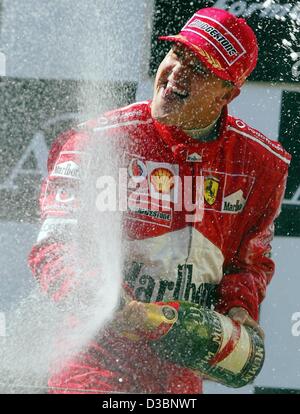 (Dpa) - tedesco di formula one champion Michael Schumacher della Ferrari jubilates con una bottiglia di champagne dopo aver vinto il Gran premio d'Austria sulla A1-Anello pista di Spielberg, Austria, 18 maggio 2003. È la sua terza vittoria di questa stagione. Foto Stock