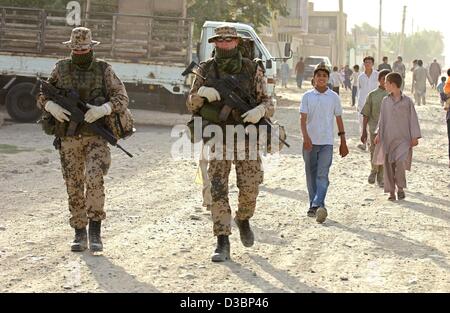 (Dpa) - Un gruppo di soldati tedeschi a piedi attraverso le strade e sono seguiti da un gruppo di giovani durante una pattuglia militare nel quarto distretto di polizia di Kabul, Afghanistan, 4 agosto 2003. La NATO assume il comando da la sicurezza internazionale Assistance Force (ISAF) il 11 agosto 2003. Alo Foto Stock