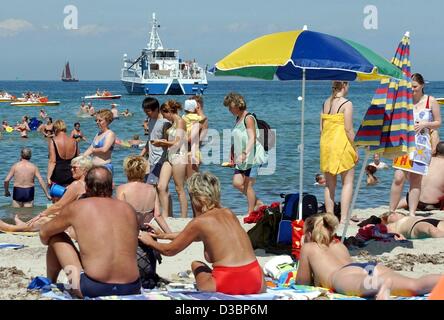 (Dpa) - vacanzieri cavort sulle spiagge di sabbia e nell'acqua rinfrescante presso una spiaggia centro balneare sul Mar Baltico in Rostock-Warnemuende, Germania, 19 luglio 2003. Foto Stock