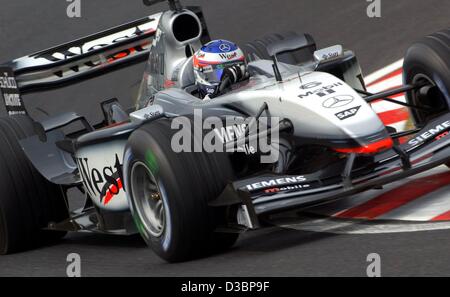 (Dpa) - Finlandese pilota di Formula Uno Kimi Raeikkoenen della McLaren Mercedes aziona attraverso una curva durante il corso di formazione gratuito sulla gara di Formula Uno via a Suzuka, in Giappone, 10 ottobre 2003. Il sedicesimo e ultimo round della Formula Uno Campionati del Mondo si terrà a Suzuka, circa 300 km a sud-ovest di a Foto Stock