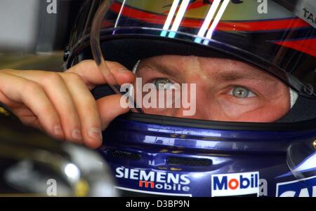 (Dpa) - Finlandese pilota di Formula Uno Kimi Raeikkoenen della McLaren Mercedes bevande con una cannuccia durante il corso di formazione gratuito sulla gara di Formula Uno via a Suzuka, in Giappone, 10 ottobre 2003. Il sedicesimo e ultimo round della Formula Uno Campionati del Mondo si terrà a Suzuka, circa 300 km a sud-ovest di Tokyo Foto Stock
