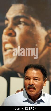 (Dpa) - Pugilato leggenda Muhammad Ali pone al di sotto di un poster che mostra Ali in epoche precedenti, come egli presenta il suo libro alla fiera del libro di Francoforte sul Meno, il 9 ottobre 2003. Il libro è intitolato "capra" (il più grande di tutti i tempi), costa 7500 Euro e pesa più di 30 kg. Il pugile, chi è segnato da Parkin Foto Stock