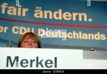 (Dpa) - Angela Merkel, presidentessa del partito di opposizione CDU, siede sul pannello del primo dei sei partito regionale conferenze a Duesseldorf in Germania, 7 ottobre 2003. La schermata di sfondo si legge "fair aendern' (modifica abbastanza). Il conservatore CDU partito sta discutendo di un concetto controverso Foto Stock