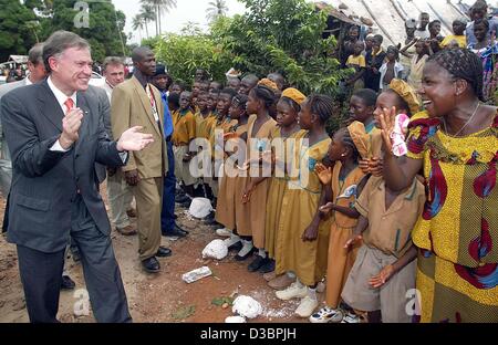 (Dpa) - Il presidente tedesco Horst Koehler (L) tubicini le mani con il ritmo di un brano di fronte ai giovani del Centro di formazione della Gesellschaft fuer Technische Zusammenarbeit (tedesco la cooperazione tecnica agenzia) a Waterloo, Sierra Leone, 8 dicembre 2004. La Koehler è su una quattro giorni di visita alla Sierra Leone Foto Stock