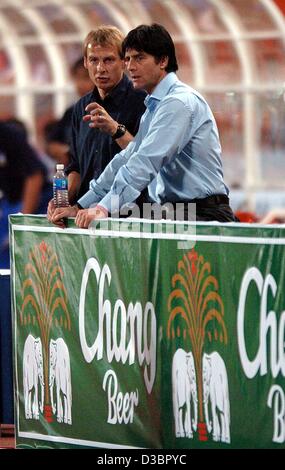 (Dpa) - Tedesco head coach Juergen Klinsmann (L) e il suo assistente Joachim Loew (R) parlare al passo durante l'amichevole internazionale tra la Tailandia e la Germania a Rajamangala National Stadium di Bangkok, Thailandia, 21 dicembre 2004. La Germania ha vinto con un punteggio finale di 5-1. Foto Stock