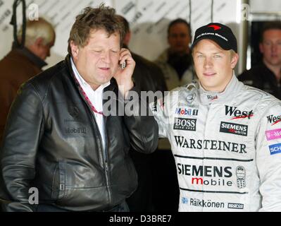 (Dpa) - Finlandese pilota di Formula Uno Kimi Raeikkoenen di McLaren-Mercedes (R) sorge accanto alla Mercedes-sport-direttore Norbert Haug dopo la sessione di qualifiche sul circuito di Indianapolis, 27 settembre 2003. Raeikkoenen cadenzato il tempo più veloce e sarà a partire dalla pole position di domenica noi G Foto Stock