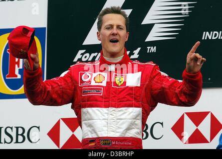 (Dpa) - tedesco di Formula Uno del campione del mondo in carica Michael Schumacher festeggia sul podio dopo alla guida della sua Ferrari alla vittoria nel Gp degli Stati Uniti a Indianapolis, 28 settembre 2003. Schumacher ha vinto davanti alla Finlandia di Kimi Raikkonen di McLaren-Mercedes e colleghi tedeschi Heinz-Harald Frentzen della Sauber. Foto Stock