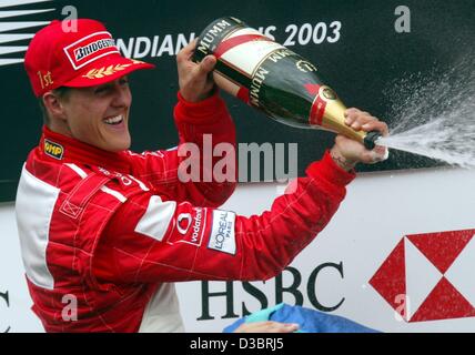 (Dpa) - tedesco di Formula Uno del campione del mondo in carica Michael Schumacher festeggia sul podio dopo alla guida della sua Ferrari alla vittoria nel Gp degli Stati Uniti a Indianapolis, 28 settembre 2003. Schumacher ha vinto davanti alla Finlandia di Kimi Raikkonen di McLaren-Mercedes e colleghi tedeschi Heinz-Harald Frentzen della Sauber. Foto Stock