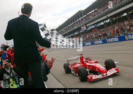 (Dpa) - Tedesco pilota di Formula uno e il campione del mondo Michael Schumacher (Ferrari) unità nella sua vettura da corsa su pista passato una tribuna con il tifo di spettatori come egli è il primo ad arrivare alla linea di finitura durante il periodo della formula uno di noi Gran Premio di Indianapolis, Stati Uniti d'America, 28 settembre 2003. Schumach Foto Stock