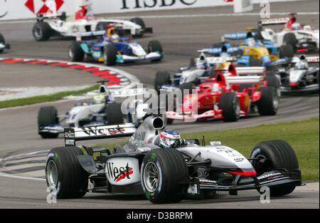 (Dpa) - Finlandese pilota di Formula Uno Kimi Raeikkoenen (McLaren-Mercedes) C, anteriore) leader nel campo delle vetture da corsa a destra dopo la partenza della US FORMULA ONE Grand Prix in Indianapolis, Stati Uniti d'America, 28 settembre 2003. In fine Raeikkoenen conquista il secondo posto. Il Gran premio degli Stati Uniti è quindicesimo e penultima gara Foto Stock