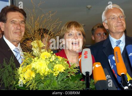 (Dpa) - La Presidentessa del partito di opposizione democratica cristiana europea (CDU), Angela Merkel, sorride dopo che lei è stato rieletto come Presidente della fazione parlamentare della CDU/CSU, party a Berlino, 23 settembre 2003. Sulla sinistra Michael GLOS, capo del partito conservatore cristiano-sociale dell'Unione (CSU) p Foto Stock