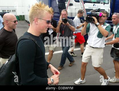 (Dpa) - Finlandese pilota di Formula Uno Kimi Raeikkoenen anteriore (L) di McLaren-Mercedes arriva all'Hungaroring race track in Budapest, Ungheria, 21 agosto 2003. Xiii eseguire dei campionati del mondo, il Gran Premio di Ungheria, avrà luogo il 24 agosto. Foto Stock