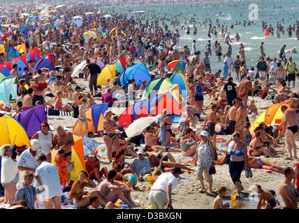 (Dpa) - Una vista di una trafficata spiaggia di sabbia lungo la spiaggia del Mar Baltico in Rostock-Warnemuende, Repubblica federale di Germania ) Agosto 2003. Temperature continua a rimanere al di sopra del 30 gradi Celsius mark e migliaia di vacanzieri di utilizzare l'occasione per una giornata in spiaggia e a seguire il XIII Hansesail regatt vela Foto Stock