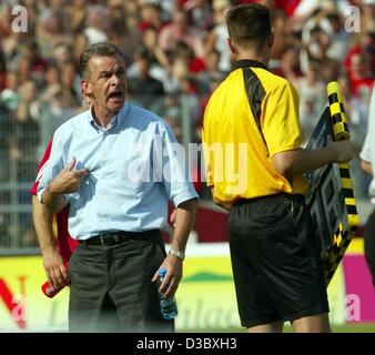 (Dpa) - del Bayern Monaco soccer allenatore Ottmar Hitzfeld (R) sostiene rabbiosamente con l'arbitro assistand durante la Bundesliga soccer game Hannover 96 contro FC Bayern Monaco di Baviera in Hannover, Germania 9 agosto 2003. La partita si è conclusa in un 3-3 cravatta. È stato il giorno più caldo della corrente Bundesliga stagione con tempe Foto Stock