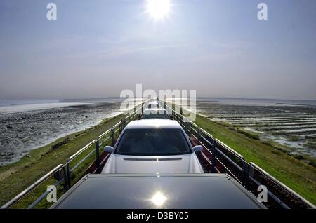 (Dpa) - Il sole si riflette sul tetto di una vettura che circola su SyltShuttle, una linea di relazioni lungo la diga di Hindenburg che collega la terraferma e l'isola di Sylt nel Mare del Nord, Germania, 29 luglio 2003. Il viaggio da Niebuell sulla terraferma a Westerland a Sylt dura circa 40 m Foto Stock