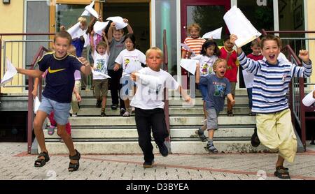 (Dpa) - prime livellatrici di una scuola elementare wave le loro relazioni scolastiche come essi cheeringly storm su schoolyard sul loro ultimo giorno di scuola prima delle vacanze estive, in Zellingen, Germania, 25 luglio 2003. Vacanze estive in Germania negli ultimi sei settimane, ma inizio e fine variano in ciascuno Stato tedesco Foto Stock