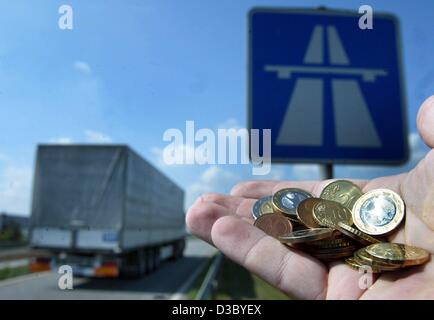 (Dpa) - una manciata di monete metalliche in euro sono visti come in background di un carrello passa un autobahn segno sulla autostrada A2 vicino a Magdeburgo (Germania), 28 luglio 2003. Inizia il 1 settembre 2003, i conducenti di veicoli pesanti in Germania dovrà pagare un pedaggio autostradale media di 12,4 centesimi di euro. Il prelievo dei pedaggi sarà b Foto Stock