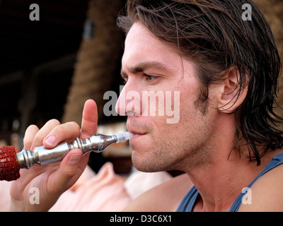 Uomo di fumare narghilè tubo in Dahab, Egitto. Foto Stock