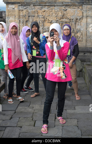 Un giovane indonesiano donna che indossa un Hijab prende una foto al Borobudur tempio buddista in Java, Indonesia Foto Stock