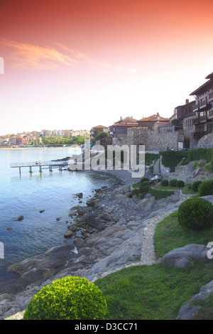 La Bulgaria, l'Europa, il Mar Nero, Sozopol, Sud fortezza muro di pietra, storico case di legno intorno al porto al tramonto. Foto Stock