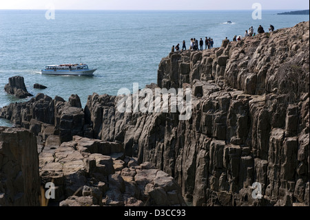 Giornata di sole turisti godendo la vista dalla cima della frastagliata e rocciosa costa sul Mare del Giappone nei pressi di Tojinbo, Fukui, Giappone. Foto Stock