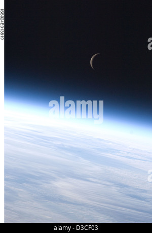 La stazione spaziale Internazionale ha catturato la Luna crescente con l'orizzonte della Terra in vista, illustrando fasi lunari, prospettiva celeste, osservazione orbitale e relazioni spaziali Terra-Luna per lo studio scientifico. Foto Stock