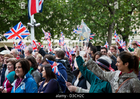 Una folla di persone che trasportano Unione Jack sono a piedi fino al centro commerciale verso Buckingham Palace durante il diamante celebrazioni giubilari, Foto Stock