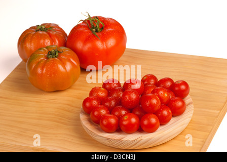 Pomodori ciliegia contro lo sfondo di tipi più grandi Foto Stock