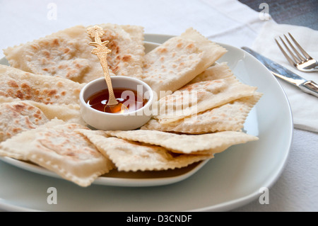 Dolci fritti fatti di fillo (o yufka) riempito con il formaggio halloumi e servito con miele Foto Stock