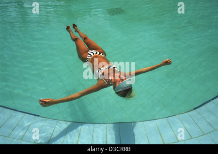 Giovane donna che indossa un bikini a prendere il sole sulla sua schiena nella piscina dell albergo Isrotel in Ein Bokek hotel resort district riva del Mar Morto Israele Foto Stock