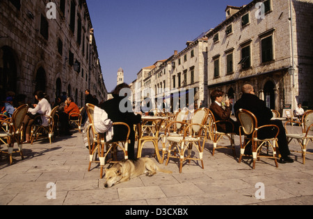 La gente seduta in ristoranti e caffetterie rivestiti in Dubrovnik la strada principale di Stradun Placa.vecchia città della Croazia Foto Stock