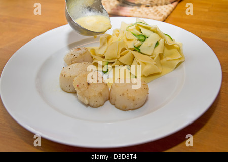 Tagliatelle allo zafferano con capesante Foto Stock