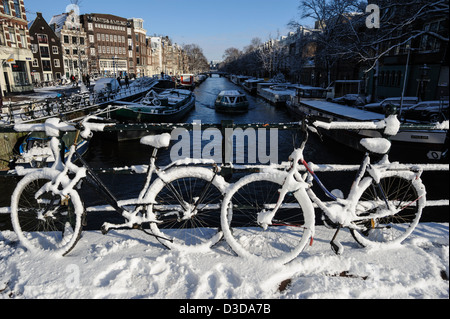 Coperta di neve biciclette sul Prinsengracht Amsterdam, Paesi Bassi Foto Stock