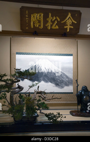 Tokonoma display del Mt. Fuji scorrere, albero di bonsai e la statua del Buddha di Hotei in zazen Sanshokaku Hall di Soto setta tempio Eiheiji Foto Stock