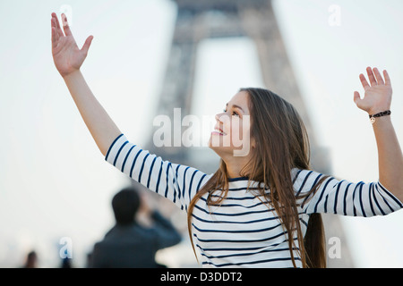 Donna che guarda eccitato con le braccia sollevate Foto Stock