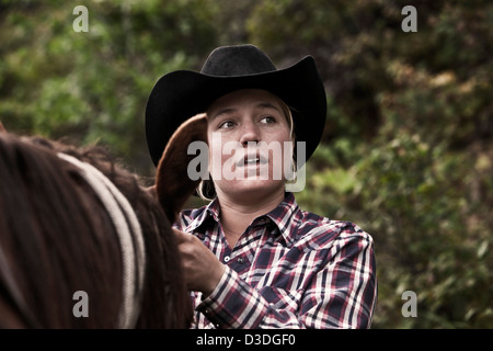 Cowgirl preparazione di cavallo, Montana ranch, STATI UNITI D'AMERICA Foto Stock